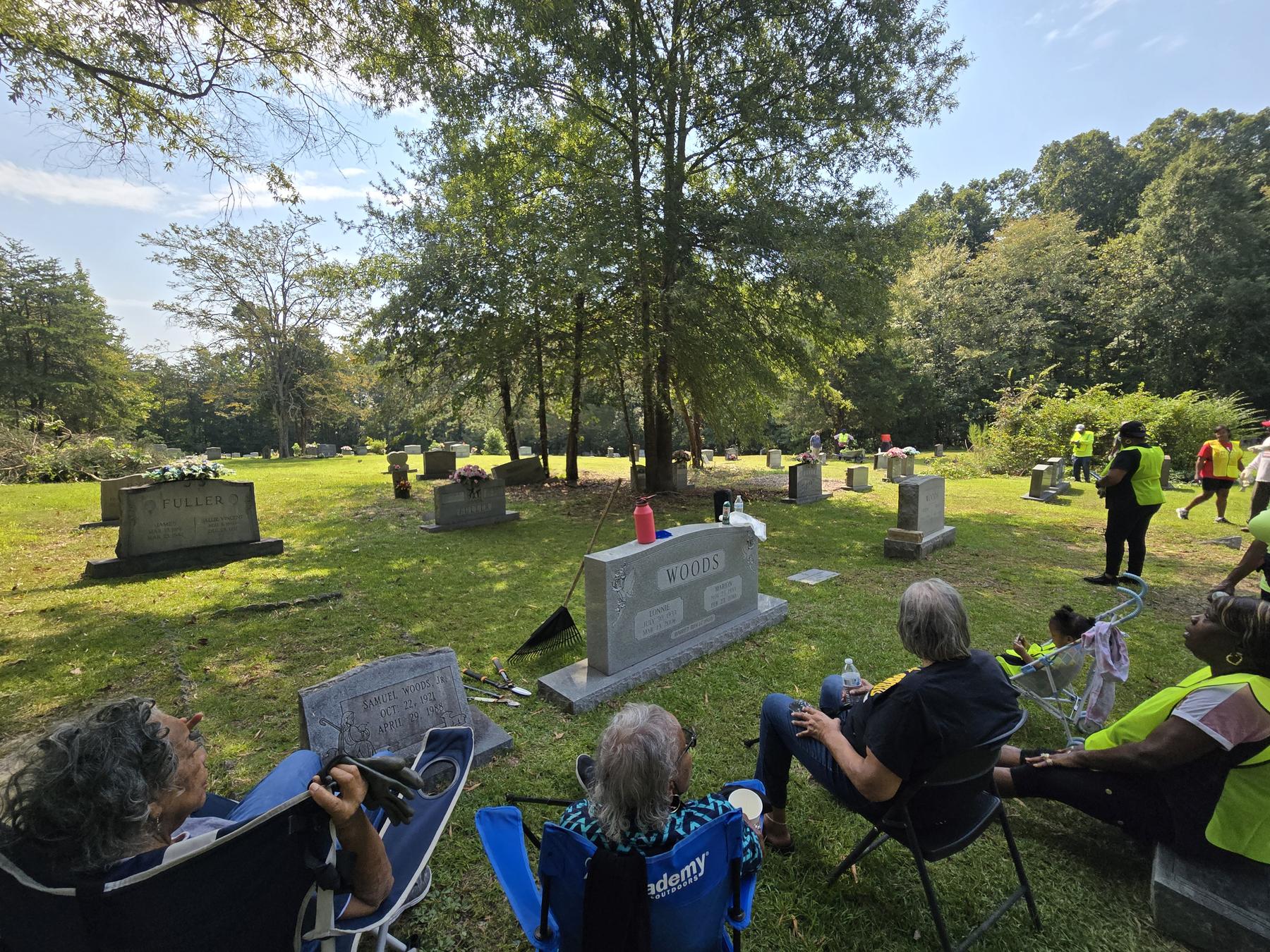 Family seated together at Snow Hill Cemetery beside Woods and Fuller family headstones