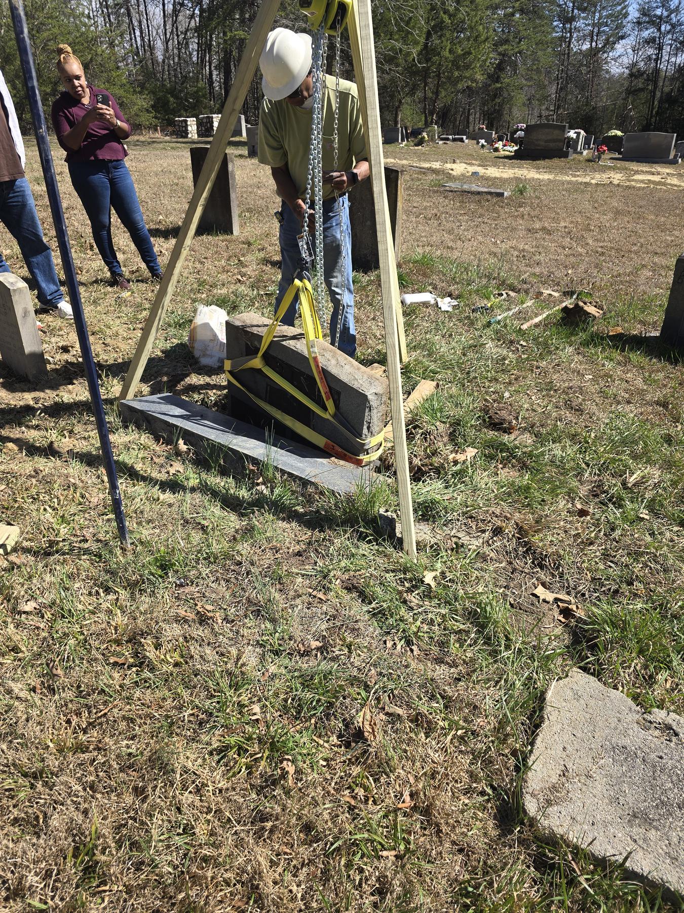 President Mike Woods working at the tripod, lifting a historic headstone